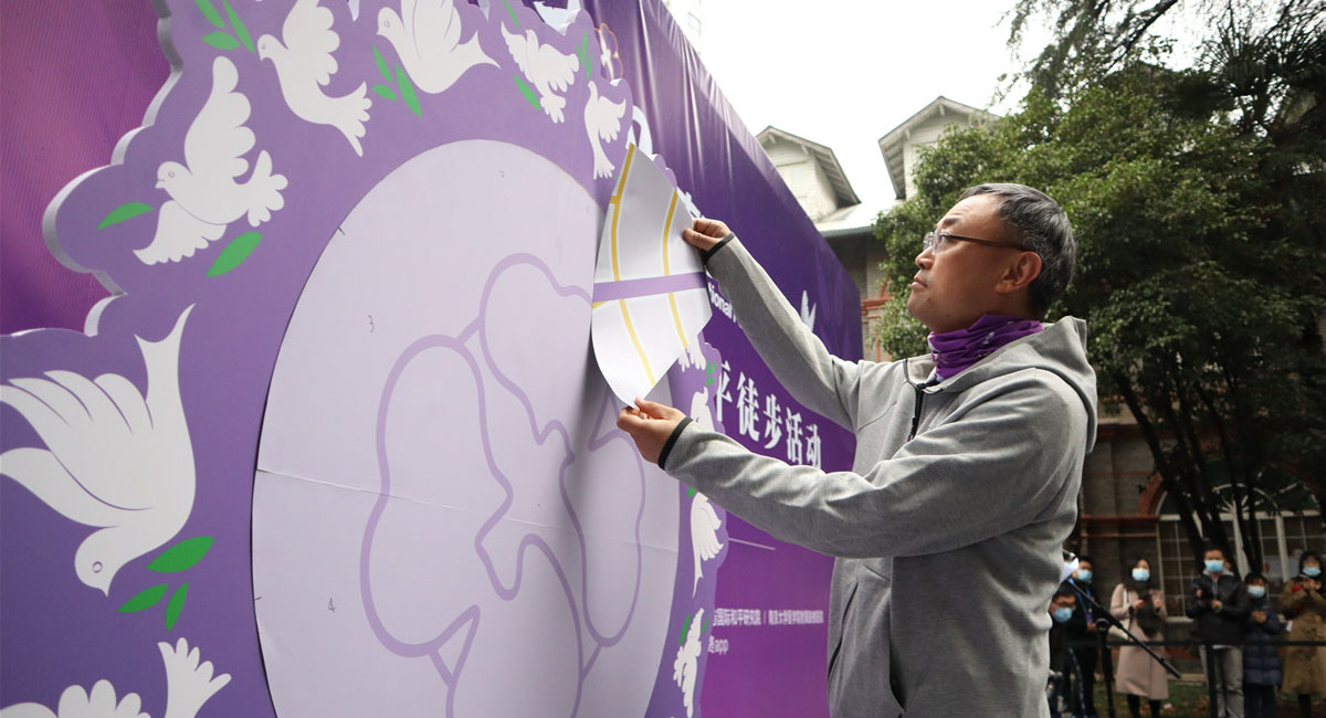 侵华日军南京大屠杀遇难同胞纪念馆馆长张建军和到场嘉宾共同拼“南京安全区”感恩拼图。