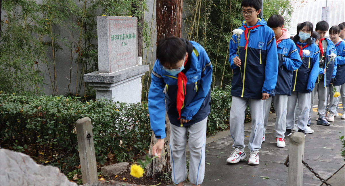 学生们在侵华日军南京大屠杀遇难同胞五台山丛葬地纪念碑前献花。